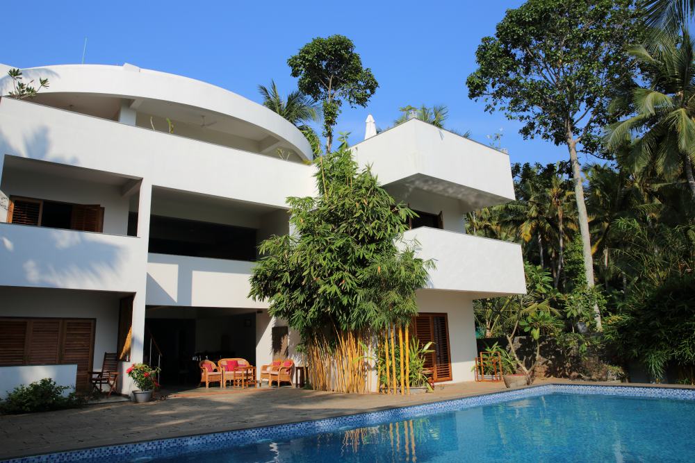 CLIFF VIEW AYURVEDA RETREAT  -  Cliff View Ayurveda Retreat, situated on the cliff above Chowara Beach, is overlooking endless blue ocean and lush green palm gardens. The white open structure of the main building is hidden in the shades of palm trees, cooled also by the fresh breeze coming from the swimming pool water in front of it.